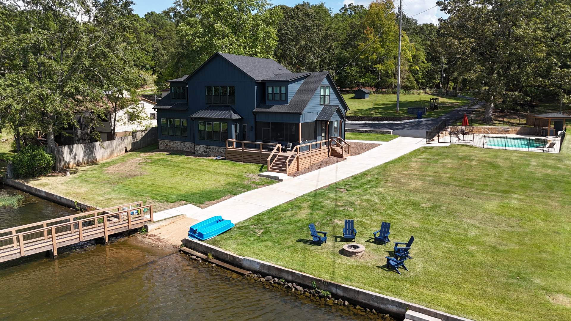 View from the water toward the house, pool, fire pit, and chairs
