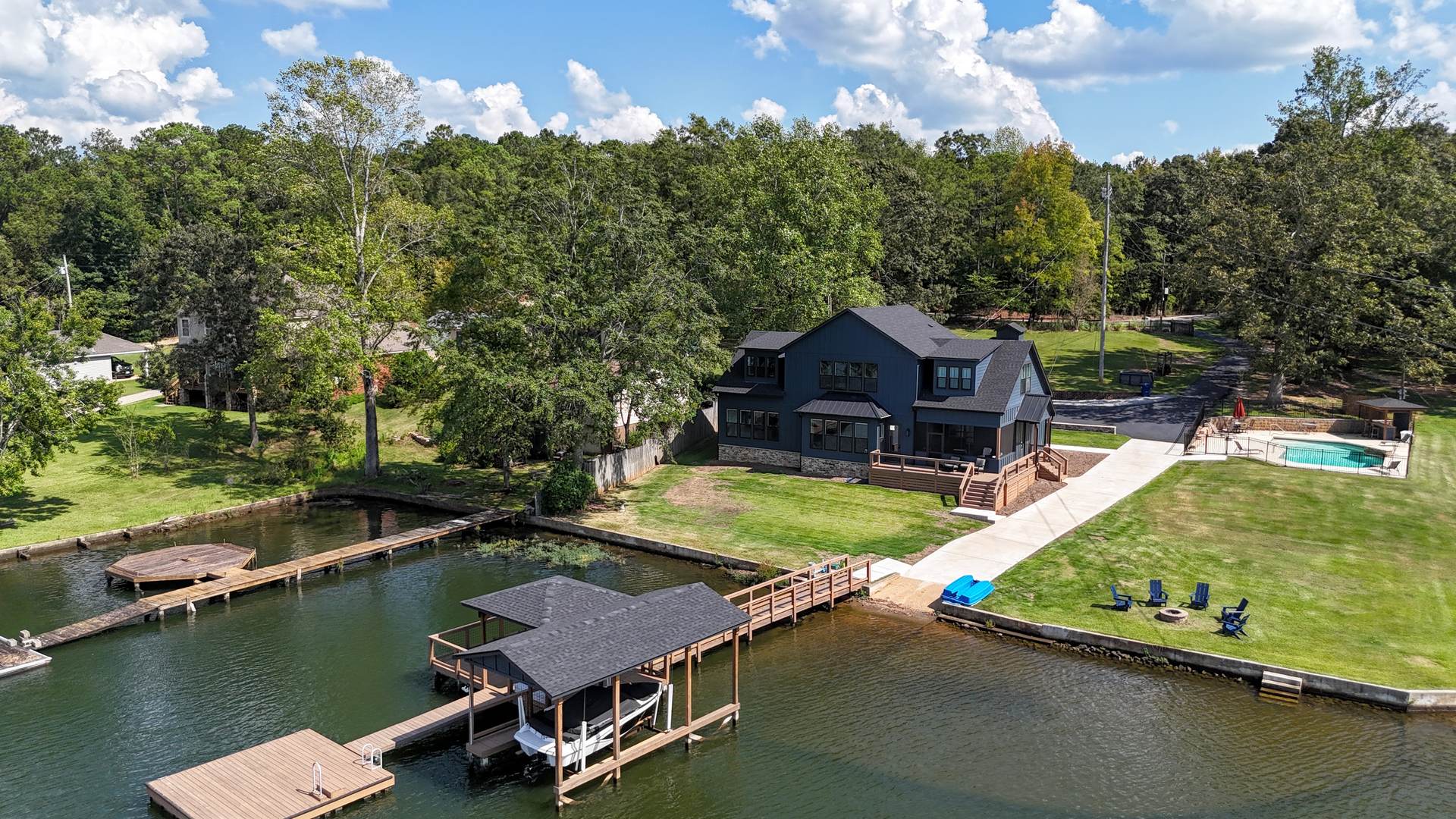 Full property from the air: house, saltwater pool, and dock with boat