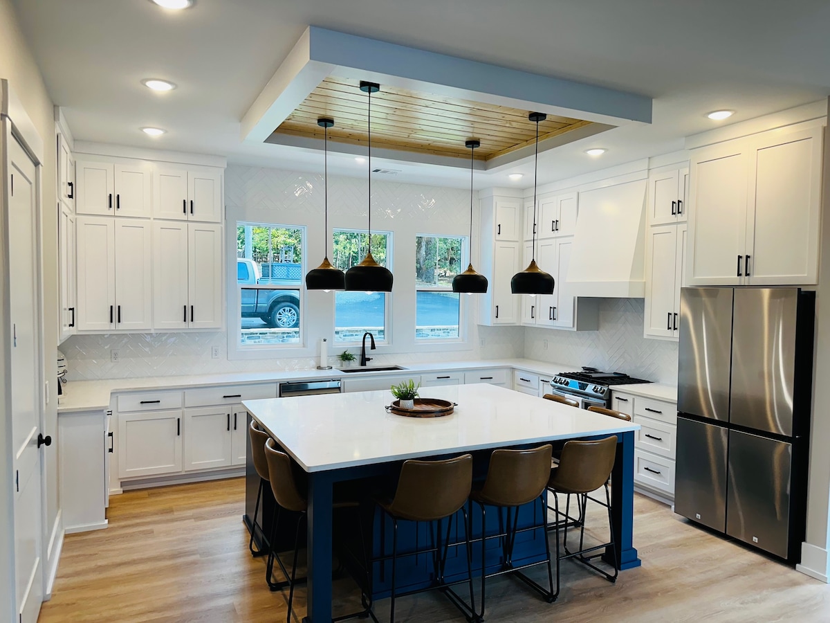 Gourmet kitchen with navy island and wood tray ceiling